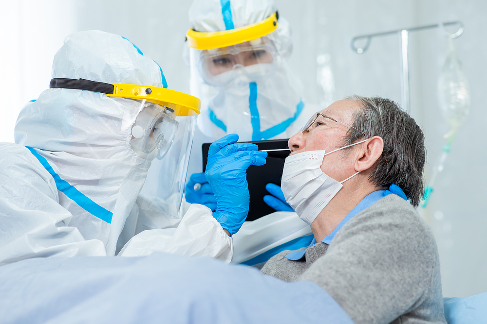 Coronavirus test - Medical worker taking a swab for corona virus sample from potentially infected elder man with the isolation gown or protective suits and surgical face masks